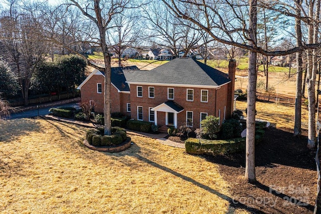 colonial home featuring a front lawn