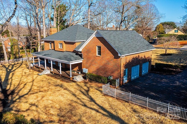 rear view of property featuring a lawn, a porch, and a garage