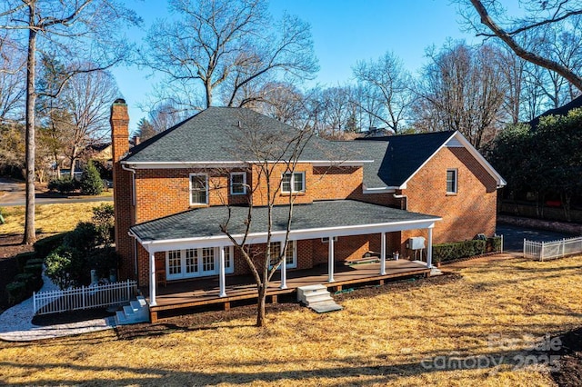 back of property with a wooden deck and a yard