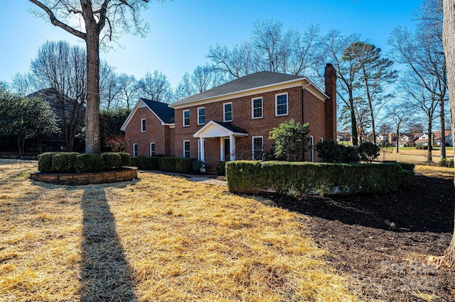 colonial house featuring a front lawn