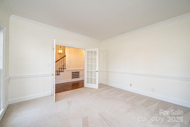 carpeted spare room with french doors and crown molding