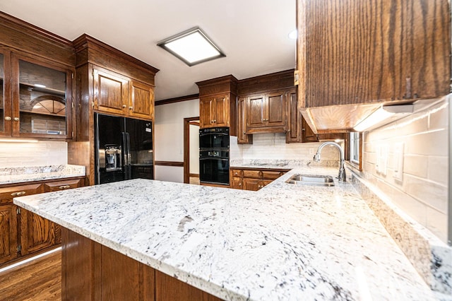 kitchen featuring backsplash, black appliances, sink, crown molding, and light stone counters