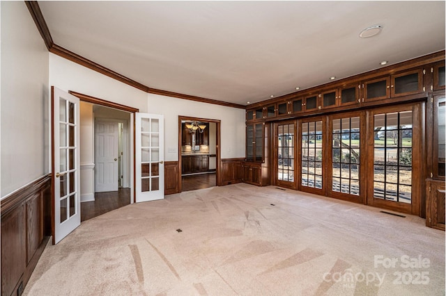 spare room with ornamental molding, light carpet, and french doors