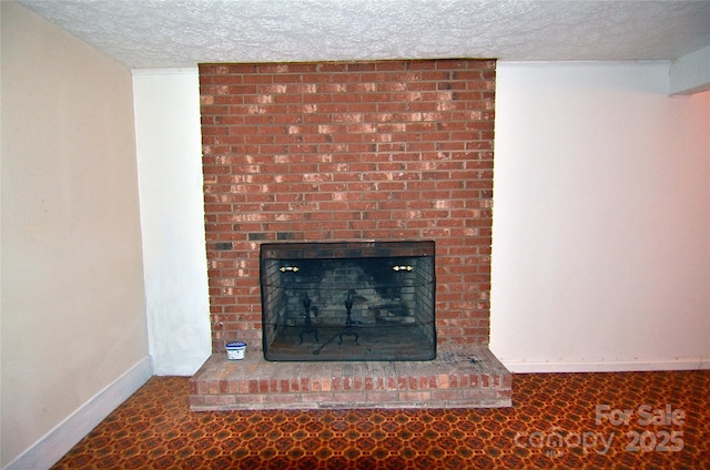 detailed view of a textured ceiling, baseboards, and a brick fireplace