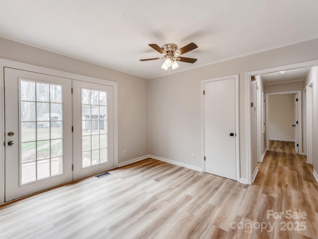 unfurnished room featuring ornamental molding, a healthy amount of sunlight, and light hardwood / wood-style flooring