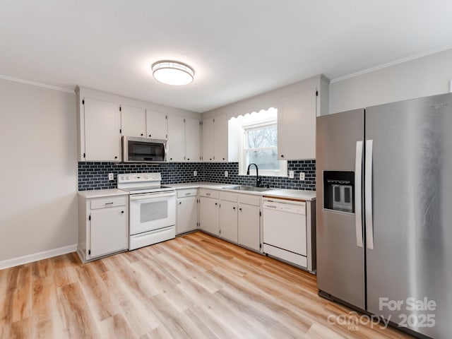 kitchen with backsplash, stainless steel appliances, sink, and white cabinets