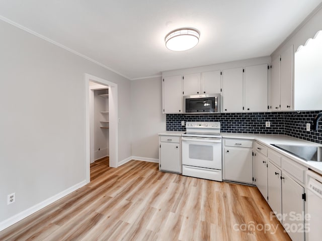 kitchen featuring backsplash, white appliances, sink, and white cabinets