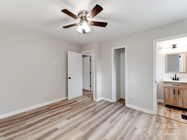 unfurnished bedroom with ensuite bathroom, sink, ceiling fan, and light hardwood / wood-style flooring