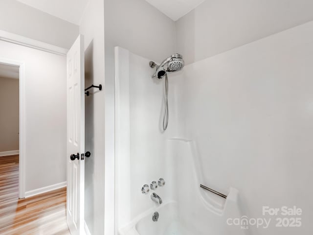 bathroom with shower / bath combination and hardwood / wood-style floors