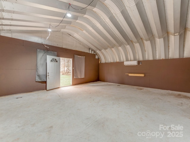 interior space with vaulted ceiling and concrete flooring