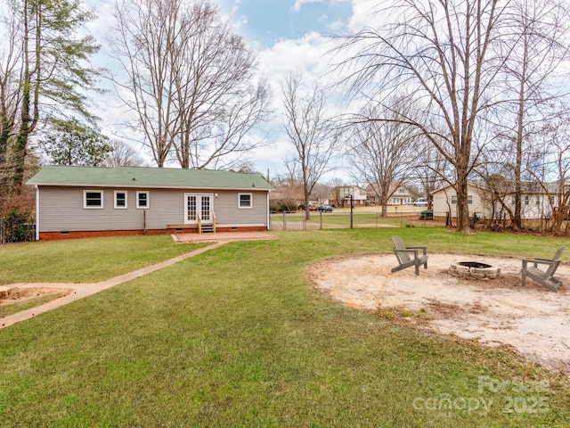 view of yard with a fire pit and french doors