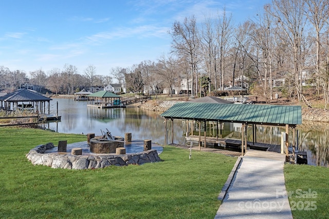 dock area featuring a gazebo, a water view, an outdoor fire pit, and a lawn