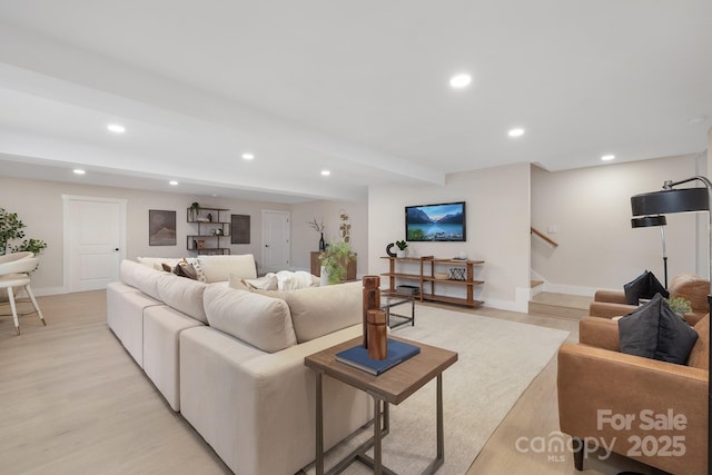 living room with light hardwood / wood-style flooring and beamed ceiling