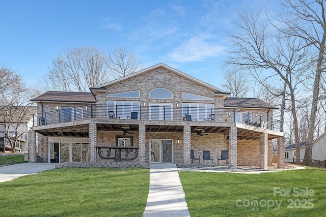 view of front facade featuring a balcony, ceiling fan, a wooden deck, and a front lawn