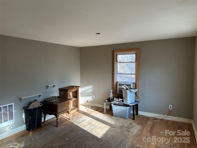 misc room with light hardwood / wood-style floors, heating unit, and cooling unit