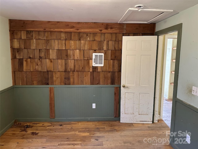 empty room with hardwood / wood-style flooring and wooden walls