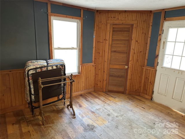 misc room featuring hardwood / wood-style flooring and wooden walls