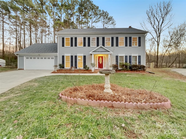 colonial-style house featuring a garage and a front yard