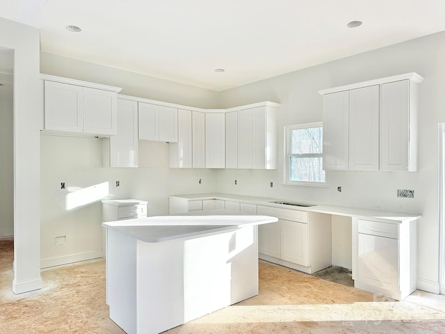 kitchen featuring white cabinetry, a kitchen island, and sink