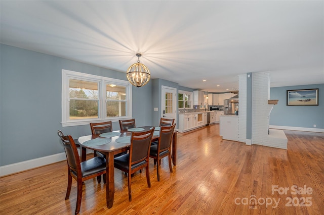 dining room with a notable chandelier and light hardwood / wood-style flooring