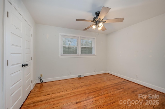 unfurnished bedroom featuring ceiling fan, light wood-type flooring, and a closet