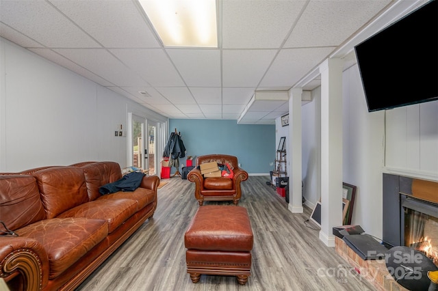 living room featuring french doors, hardwood / wood-style floors, and a drop ceiling