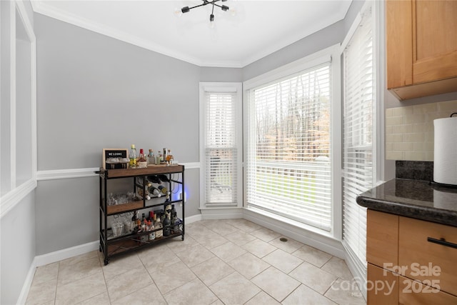 tiled dining area with a wealth of natural light and ornamental molding