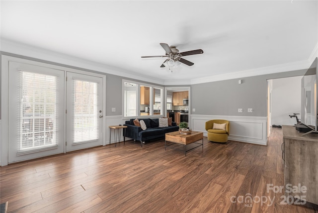 living room featuring hardwood / wood-style flooring, ceiling fan, and crown molding