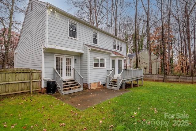 rear view of property with a yard, a patio, and a deck