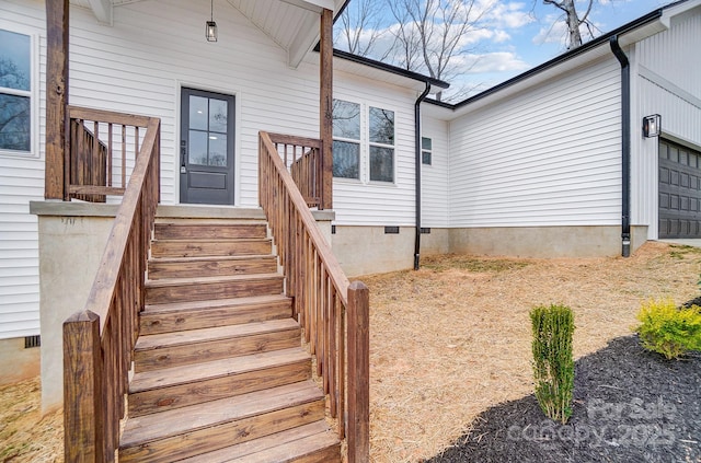 view of exterior entry with crawl space and an attached garage