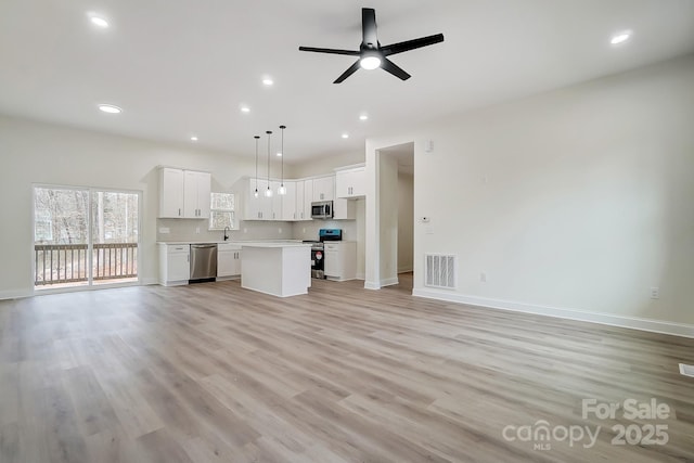 unfurnished living room with a ceiling fan, light wood-type flooring, visible vents, and recessed lighting