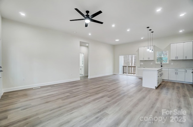 kitchen with open floor plan, light countertops, light wood-style flooring, and decorative backsplash