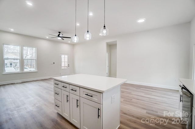 kitchen with recessed lighting, open floor plan, a center island, light wood finished floors, and decorative light fixtures