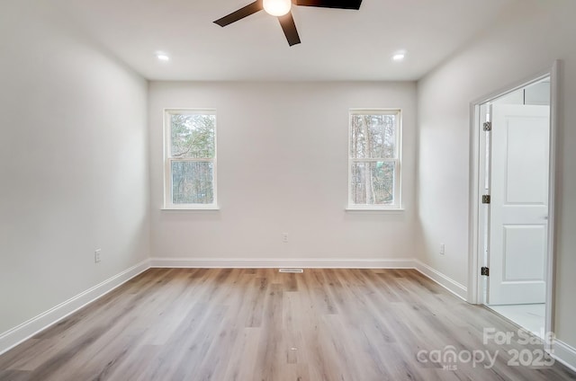 empty room featuring baseboards, light wood-style flooring, and a healthy amount of sunlight