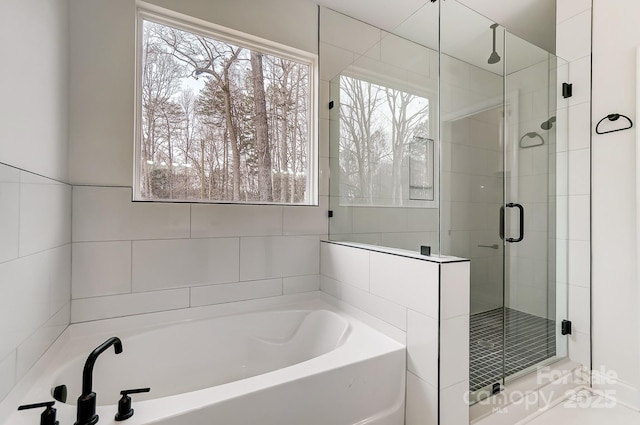 full bathroom featuring a stall shower and a garden tub