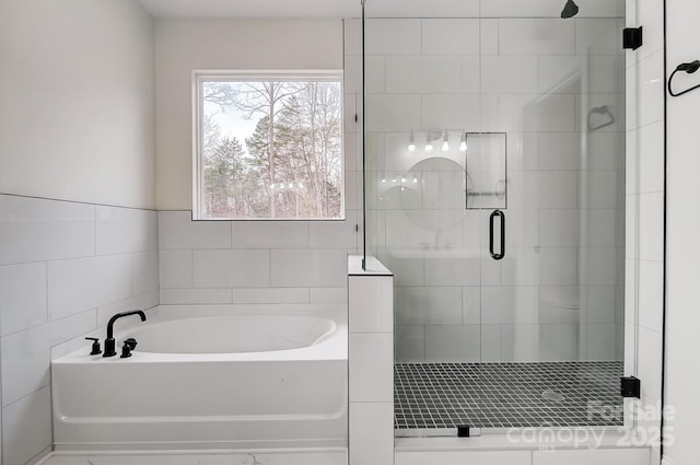 bathroom with a stall shower, tile walls, and a bath