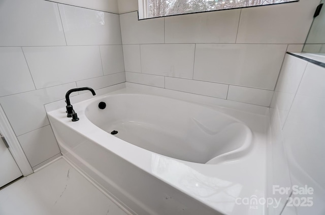 bathroom featuring tile walls and a bath