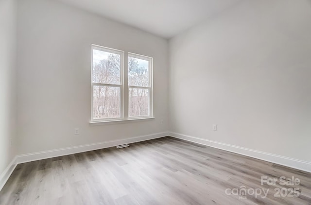 unfurnished room with baseboards and wood finished floors