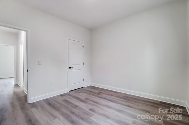 spare room featuring wood finished floors and baseboards