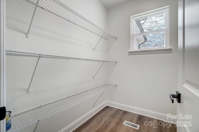 walk in closet featuring dark wood-style floors and visible vents