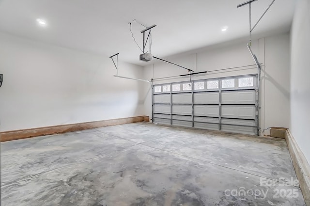 garage with a garage door opener and baseboards