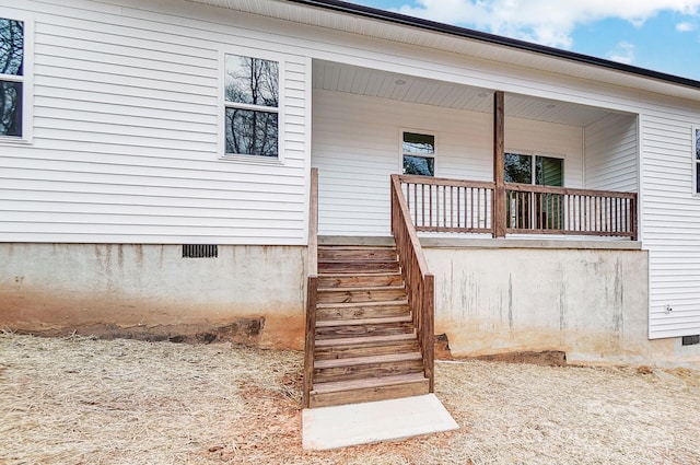 view of exterior entry with crawl space and a porch