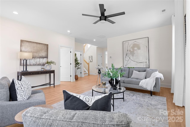 living room with wood-type flooring and ceiling fan