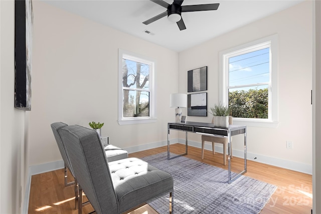 office space featuring wood finished floors, visible vents, and baseboards