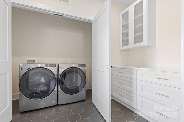 laundry area featuring dark tile patterned flooring, laundry area, and washer and clothes dryer