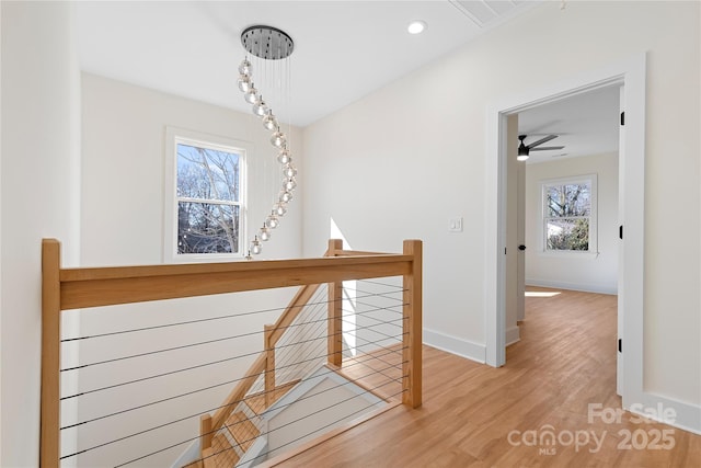 hallway featuring an upstairs landing, recessed lighting, baseboards, and wood finished floors