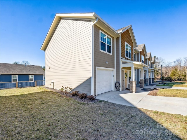 view of side of home featuring a garage and a lawn