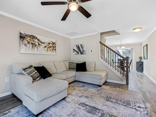 living room featuring hardwood / wood-style flooring, ceiling fan with notable chandelier, and ornamental molding