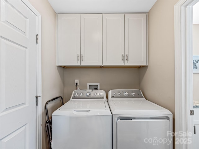 washroom featuring washing machine and dryer and cabinets