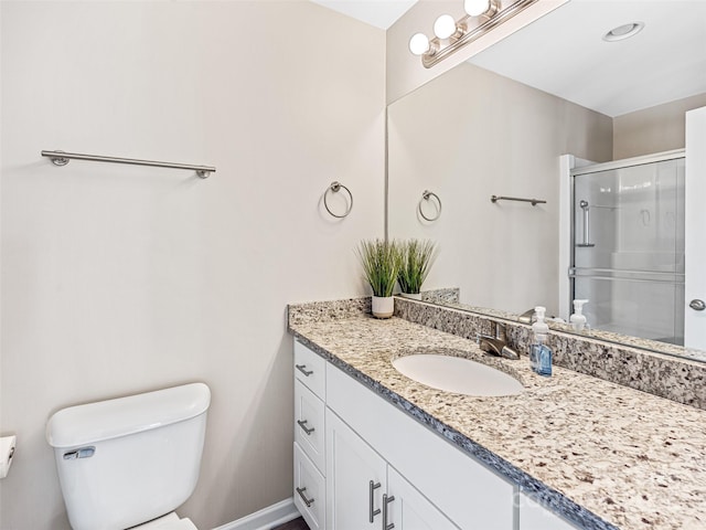 bathroom with vanity, a shower with shower door, and toilet